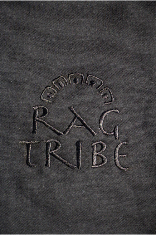 Embroidered 'RAG TRIBE' logo on a dark fabric background