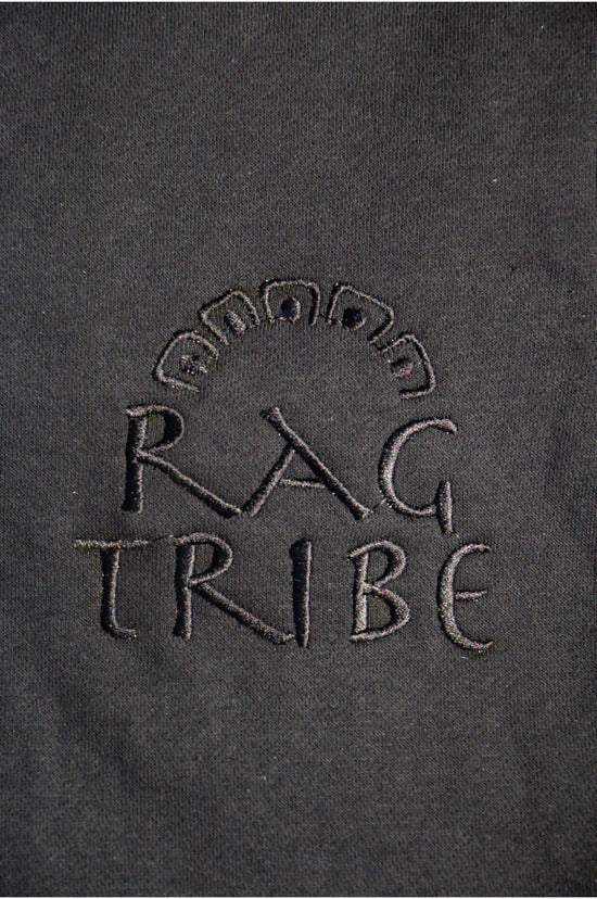 Embroidered 'RAG TRIBE' logo on a dark fabric background